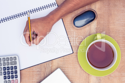 Businessman writing on book at desk