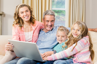 Happy family using laptop on the sofa