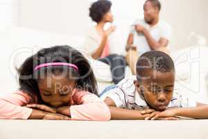Unhappy kids lying on the floor