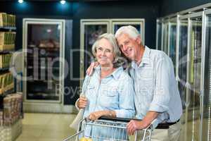 Smiling senior couple with cart