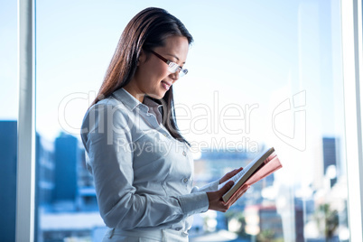 Smiling businesswoman reading book