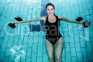 Fit smiling woman doing aqua aerobics