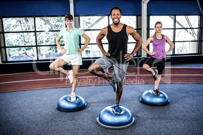 Fit people doing exercise with bosu ball