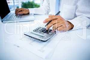 Businessman working with laptop and calculator