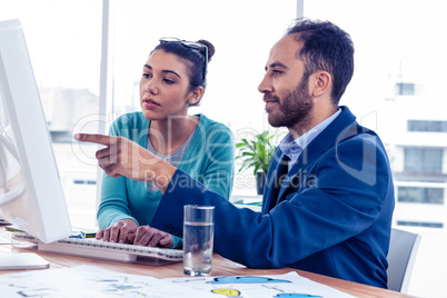 Serious business people discussing over computer