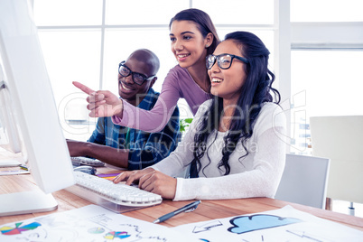 Happy businesswoman explaning to colleagues on computer