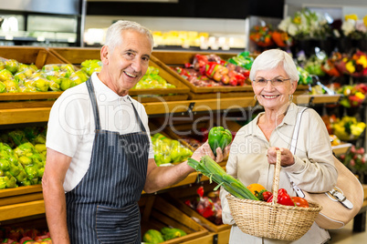 Senior customer and worker discussing vegetables