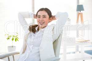 Smiling businesswoman with hands behind head