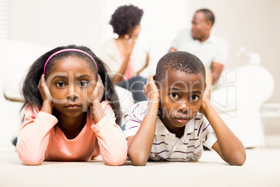 Unhappy kids sitting on the floor