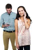 Smiling couple using smartphones