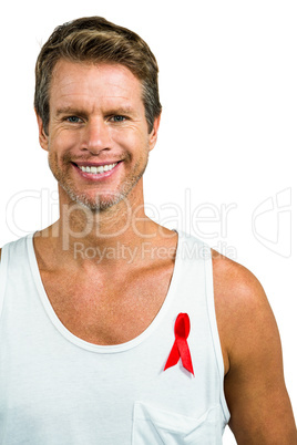 Smiling man wearing aids ribbon on vest