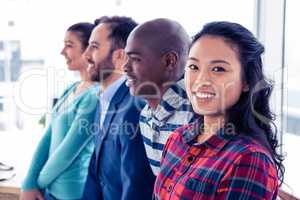 Portrait of young businesswoman standing with colleagues