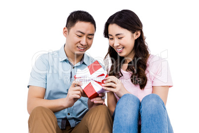 Cheerful couple holding gift box