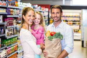 Smiling family with grocery bag at the supermarket