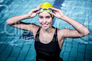 Smiling swimmer woman holding her swimming glasses