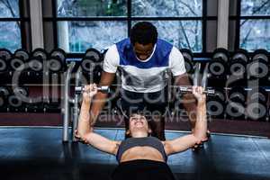 Male trainer assisting fit woman