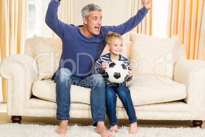 Father and son exulting on the sofa
