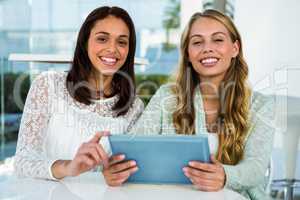 Two girls use a tablet
