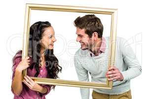 Stylish couple holding picture frame
