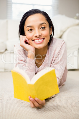 Smiling brunette reading book