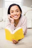 Smiling brunette reading book