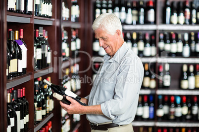 Smiling senior man choosing wine