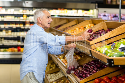 Senior man buying red onion