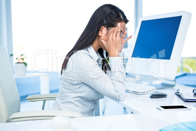 Unsmiling businesswoman with hands on face