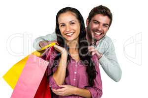 Portrait of cheerful couple holding colorful shopping bags