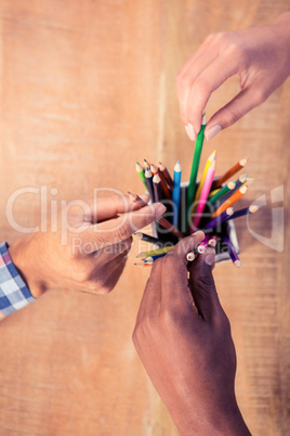 Business people choosing pencils from container