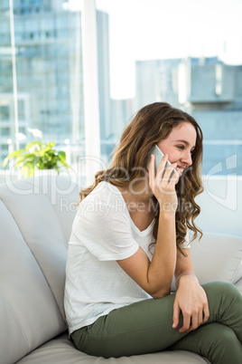 Happy woman calling on sofa