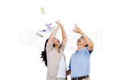 Happy couple throwing money in the air