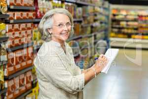 Senior woman checking list at the supermarket