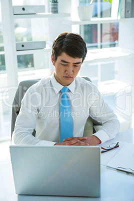 Thoughtful asian businessman at his desk