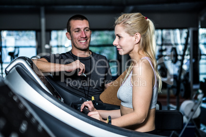 Fit woman with trainer using treadmill
