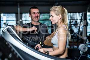 Fit woman with trainer using treadmill