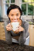 Smiling brunette holding white cup