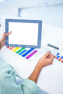 Businesswoman using her digital tablet while holding a credit ca