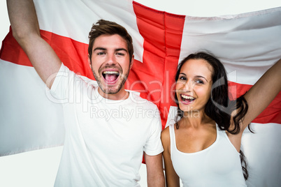 Portrait of happy couple holding English flag