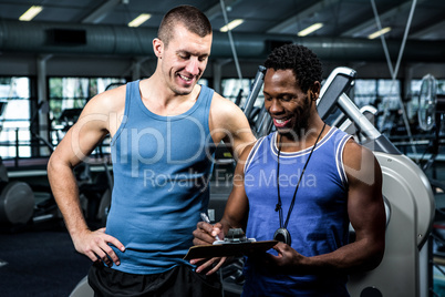 Muscular man discussing performance with trainer