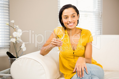 Smiling brunette holding glass of white wine