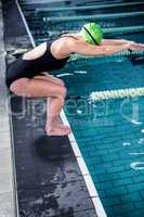 Swimmer woman about to dive into swimming pool