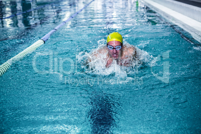 Fit man swimming with swimming hat