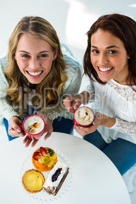 two girls drink coffee