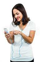 Cheerful woman listening music while using mobile phone