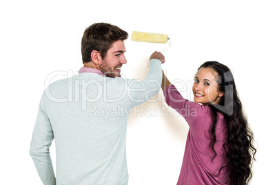 Smiling couple holding paint roller