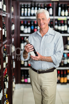 Smiling senior man choosing wine