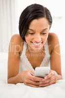 Smiling brunette using smartphone