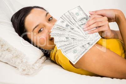 Happy brunette showing banknotes