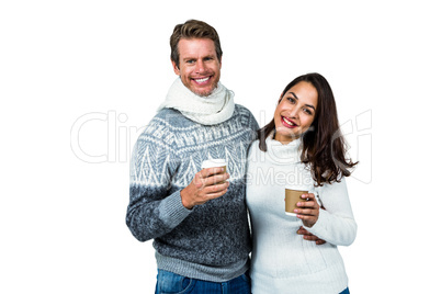 Festive couple smiling and holding mugs